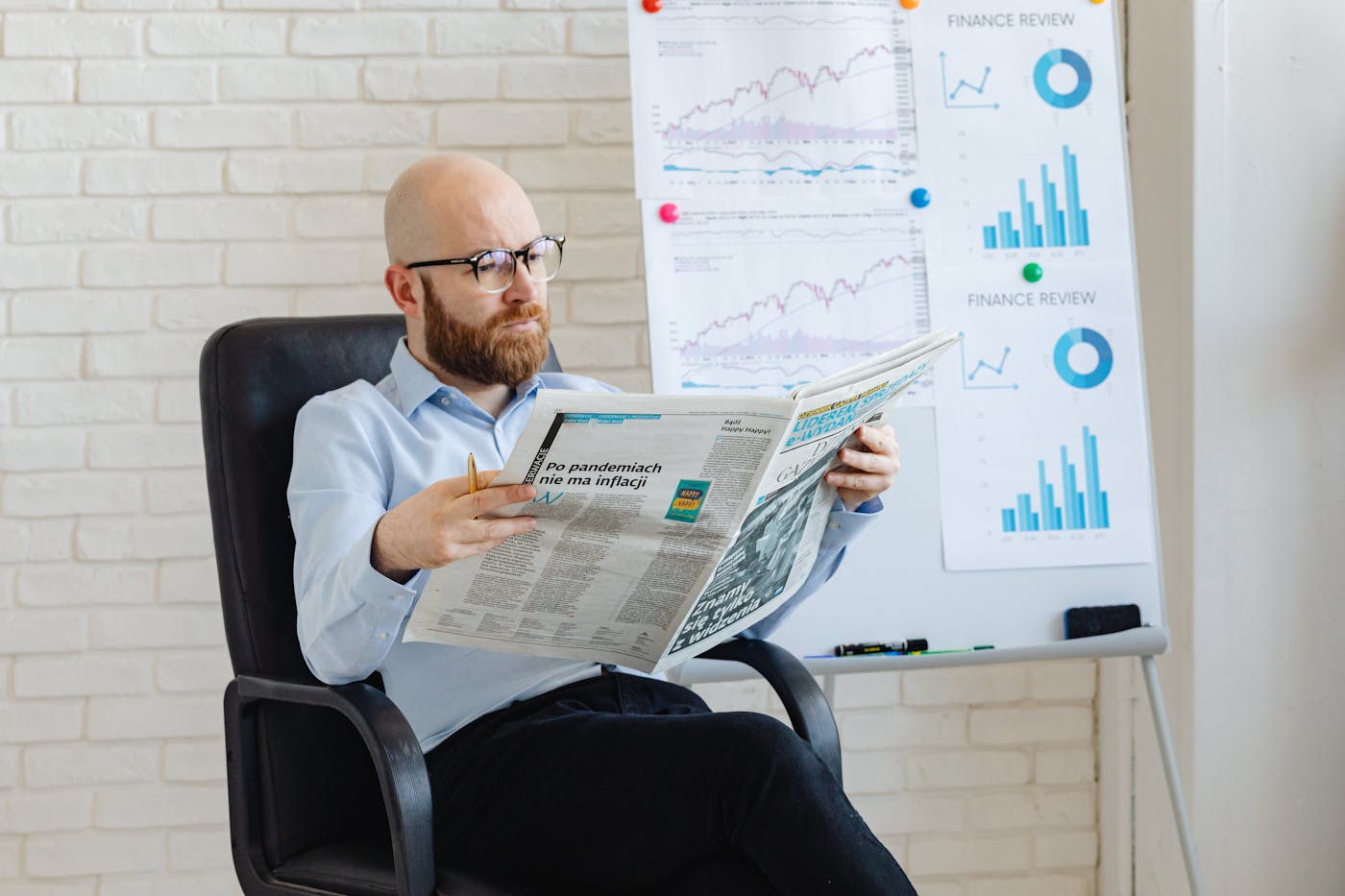 Advisor reading market news in front of financial research boards